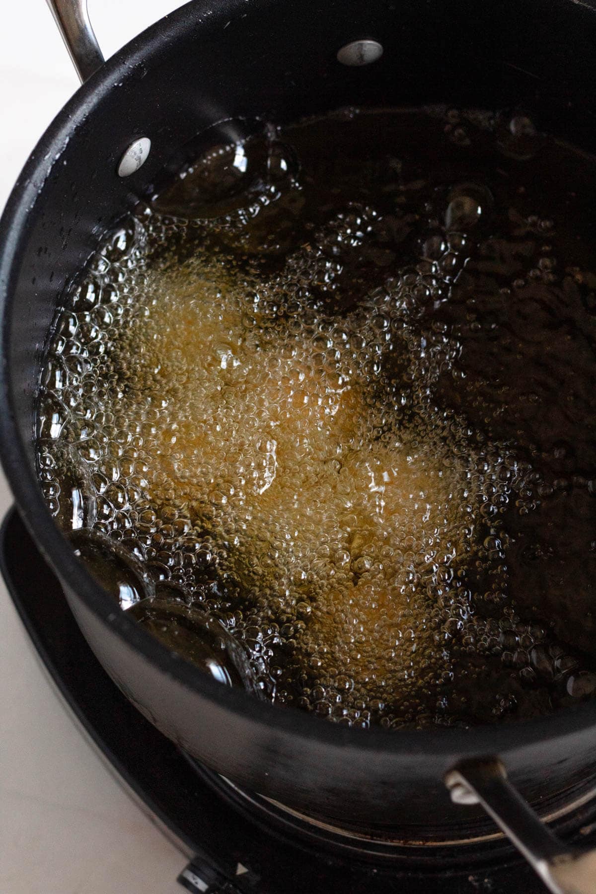 Bitterballen frying in hot oil until golden and crisp.