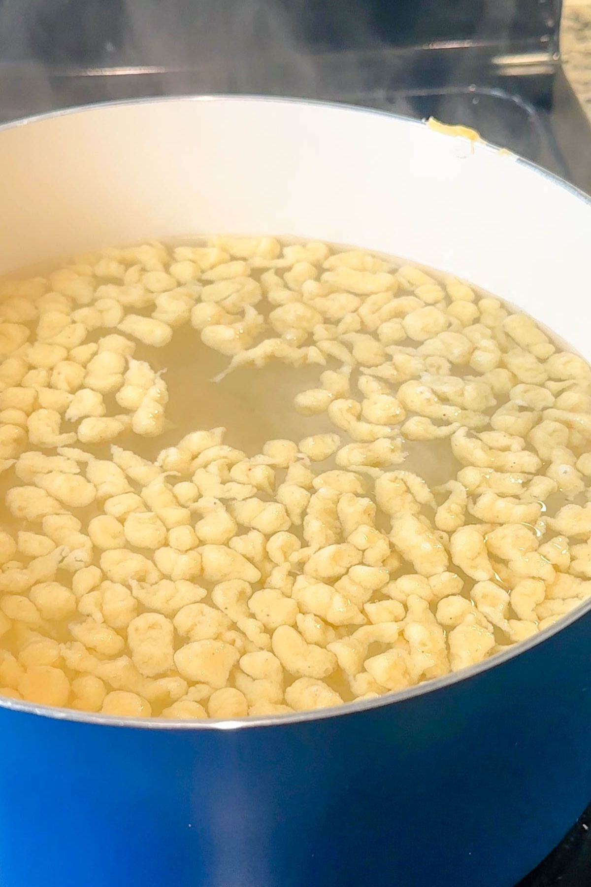 Homemade spaetzle cooking in boiling water until tender.